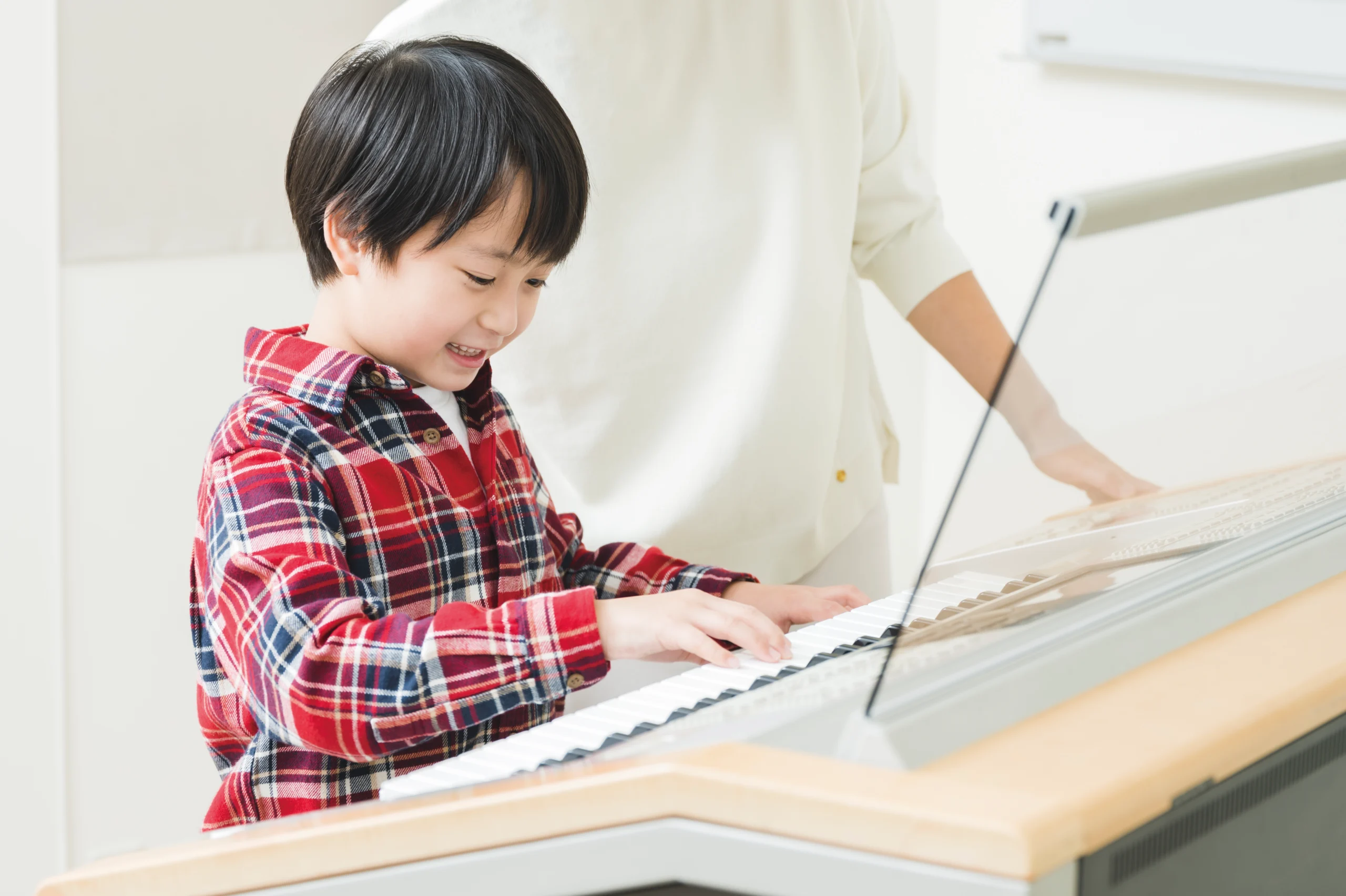 Happy young boy playing an Electone keyboard during a fun Yamaha Music School lesson – hands-on musical learning for kids.