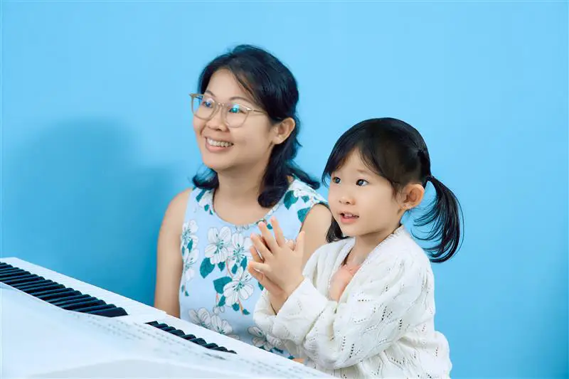 Children learning piano alongside their parents in a Yamaha Music School keyboard class
